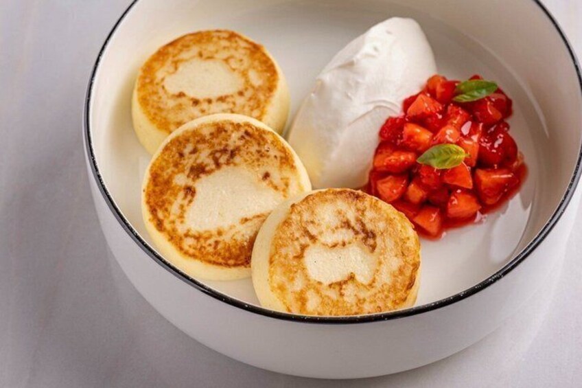Three pancakes, a scoop of ice cream, and a strawberry compote in a bowl. 2