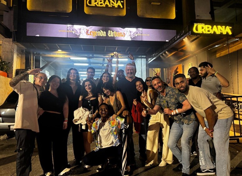 A group of people posing in front of a building with a sign that reads 'URBANA.' 3