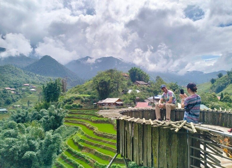 Terraced rice fields, a wooden fence, and a mountainous landscape with houses. 4