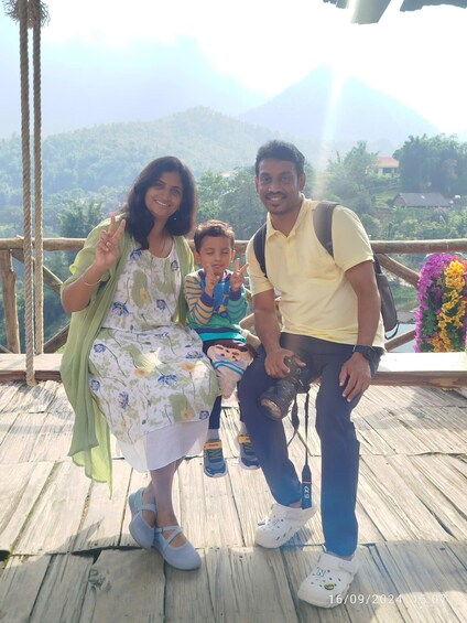 A family on a wooden deck with a mountainous landscape in the background. 5