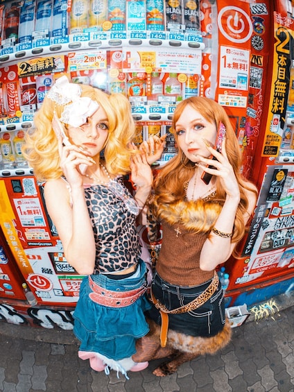 Two people posing in front of a vending machine with various drink options. 1