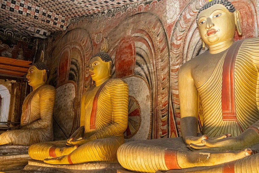 Large golden Buddha statues in a temple with intricate wall carvings. 2