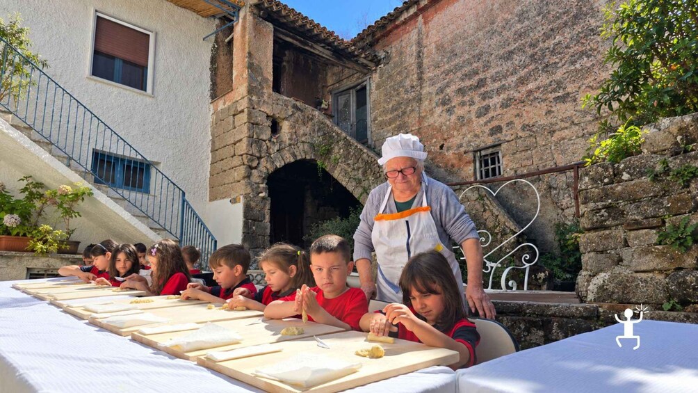 Children learning to cook outdoors with an instructor. 3