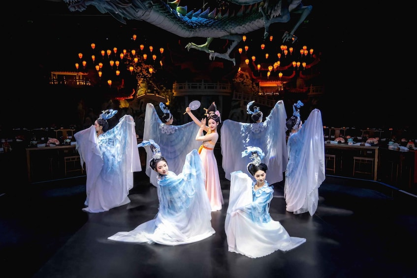 A stage with performers in white and blue costumes, a dragon overhead, and traditional lanterns. 4