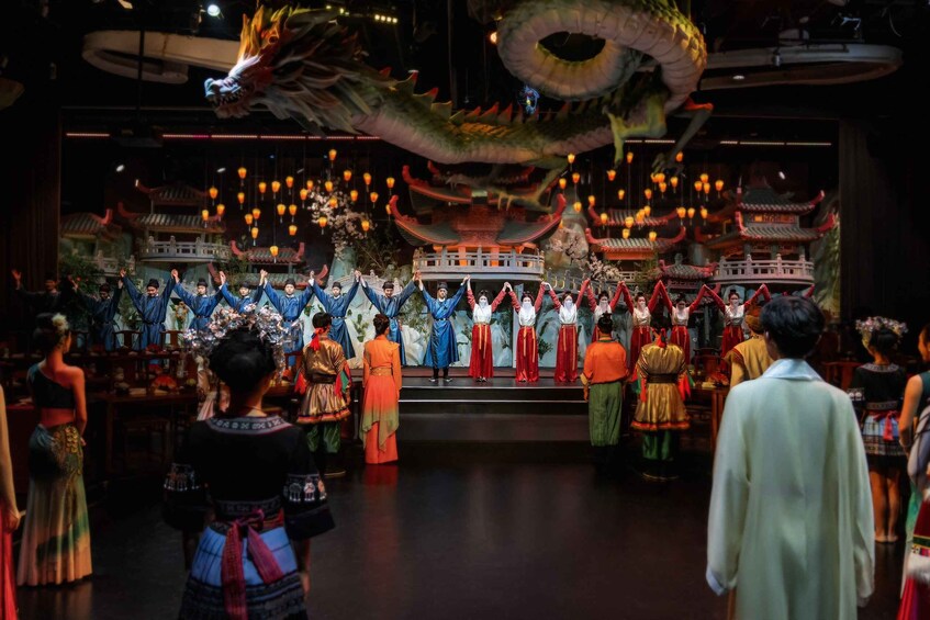 A dragon sculpture above a stage with performers in traditional costumes. 3