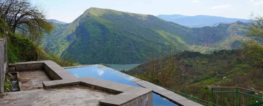A swimming pool with a view of a mountainous landscape. 1