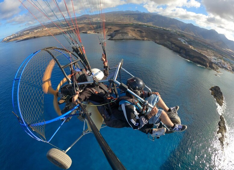 A paragliding scene with a mountainous landscape in the background. 4