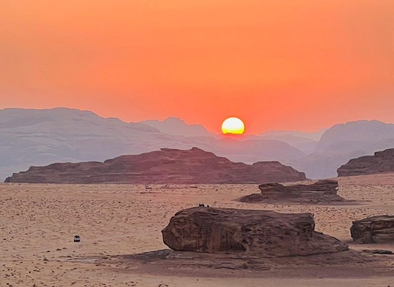 A desert landscape with a sunset, rocky formations, and a clear sky. 5