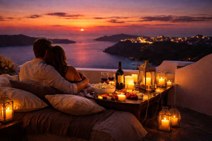 A couple on a balcony overlooking a sunset with candles and a bottle of wine. 2