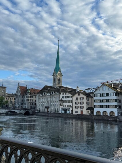 A river with a bridge, a clock tower, and historic buildings along the banks. 1