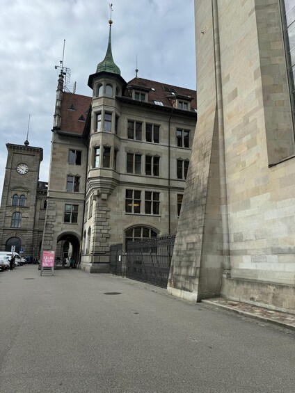 A historic building with a clock tower and a green spire. 2