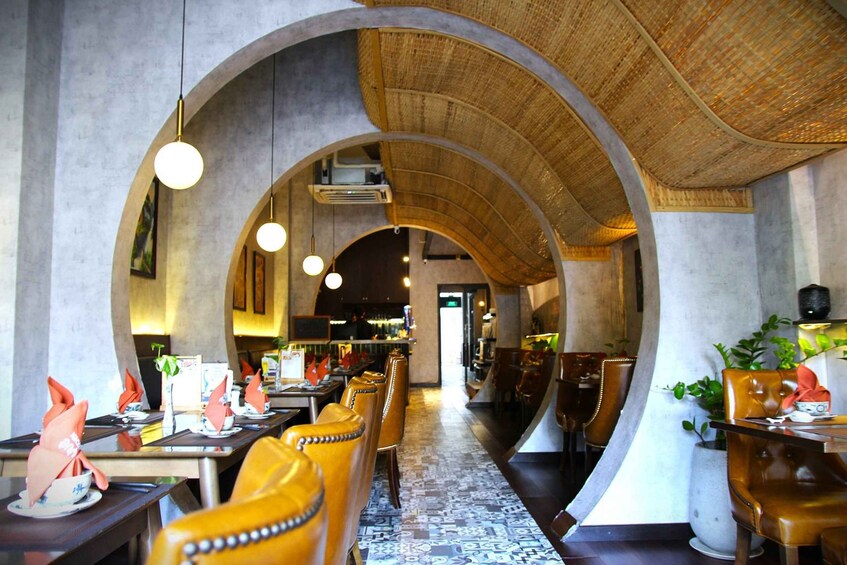 A restaurant with arched ceilings, leather chairs, and a patterned floor. 2