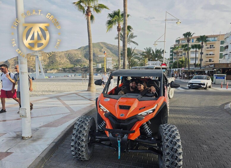 A red off-road vehicle parked on a paved area with palm trees and buildings in the background. 2