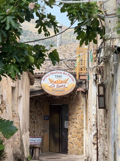 A rustic stone building with a sign for 'Antico Panificio dei Parrini' dating back to 1945. 2