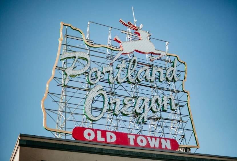 A neon sign with 'Portland Oregon' and 'Old Town' text, mounted on a metal structure. 1