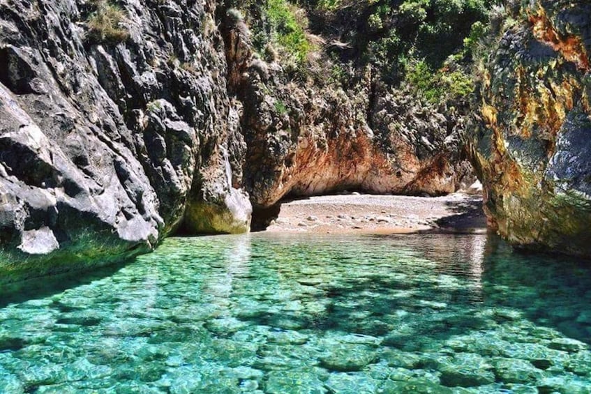 A clear, rocky waterway surrounded by cliffs. 3
