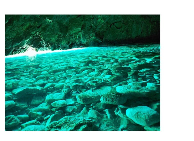 A clear underwater view of a rocky seabed with sunlight filtering through the water. 1