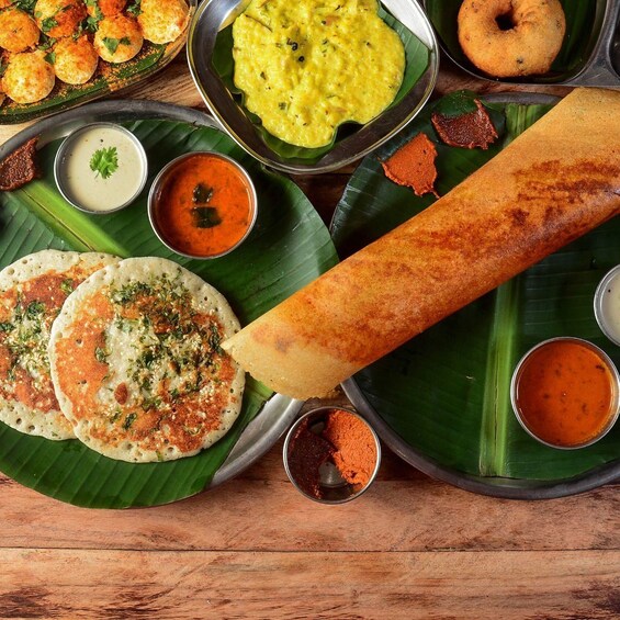 A variety of South Indian dishes, including idlis, dosas, and a coconut chutney. 3