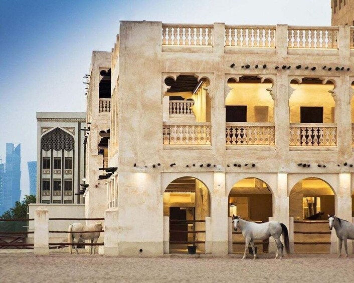 A historic building with arched doorways and a balcony. 5