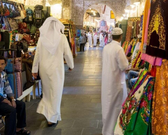 A market with people in traditional attire walking through. 5