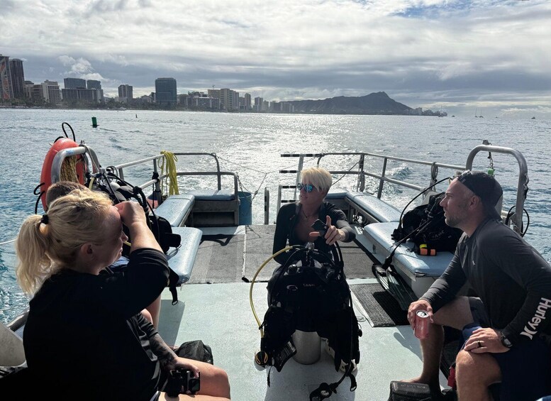 A group of people on a boat with a city skyline and mountains in the background. 5