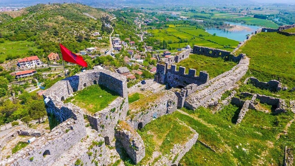 An aerial view of a historic fortified town with surrounding green fields and a river. 4