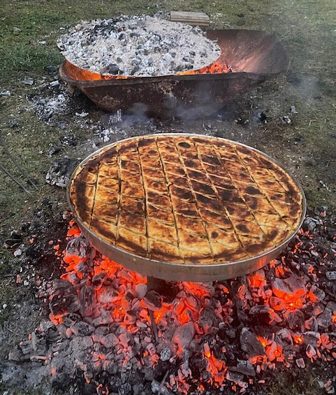 A round grill with a grid pattern, cooking over glowing charcoal. 3