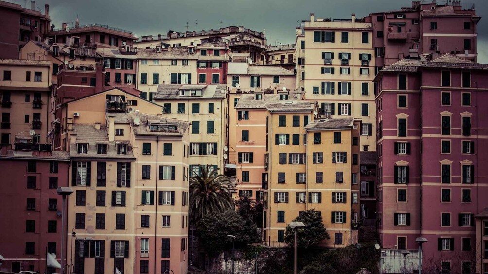 A densely packed urban area with multi-story buildings, some with balconies, under a cloudy sky. 3