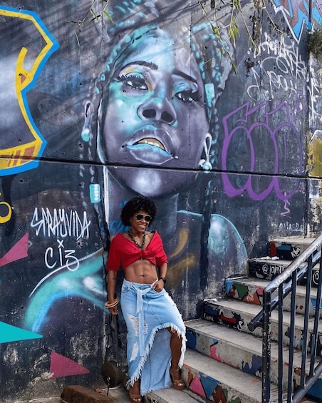 A person sitting on stairs with graffiti on the wall behind them. 2