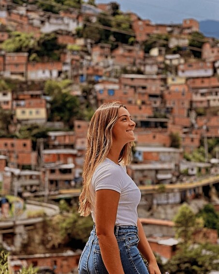 A person standing with a view of a densely packed hillside of terraced houses. 3