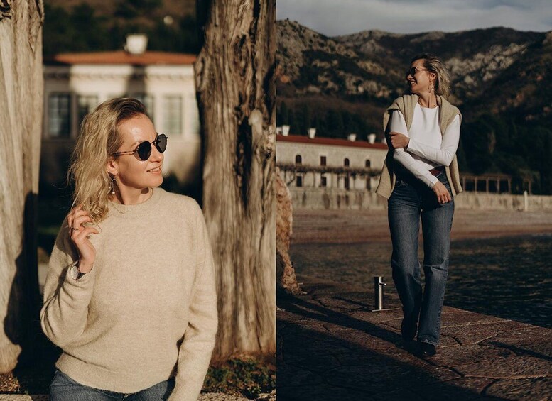 A person in a beige sweater and jeans, standing near a tree and a stone wall with a mountainous backdrop. 3