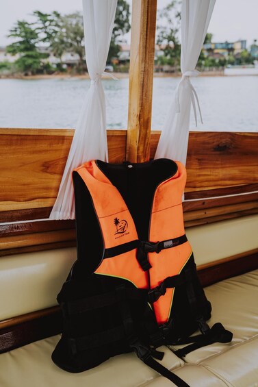 A life jacket on a wooden bench by a window overlooking a body of water. 3
