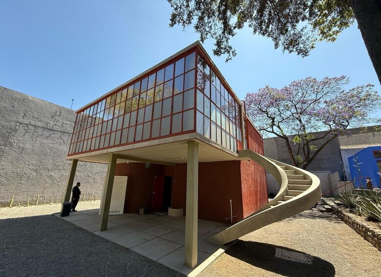 A modern building with a glass facade and a curved staircase leading to a second floor. 4