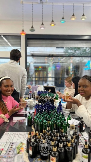 A group of people at a table with various bottles and containers, likely in a workshop or educational setting. 4