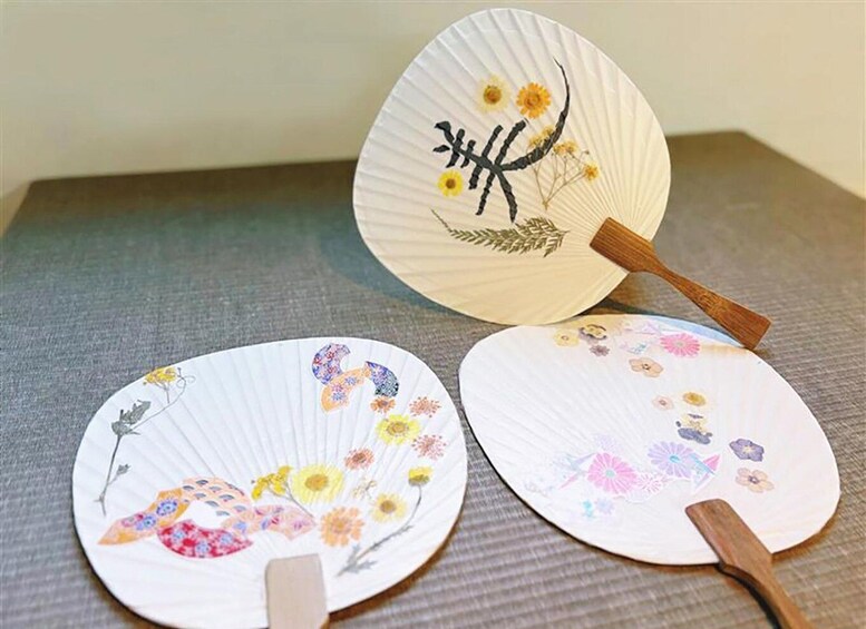 Three paper fans with floral designs. 2
