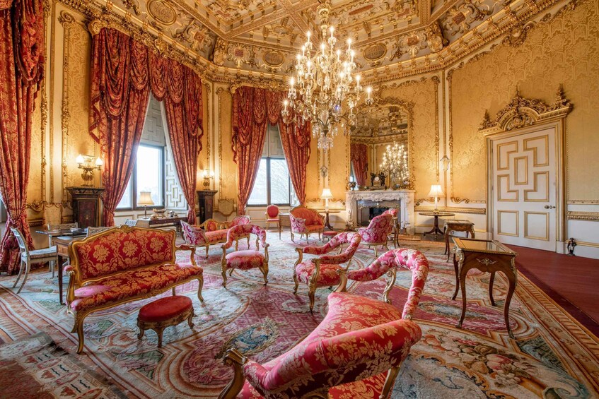 An opulent room with ornate furniture, a grand chandelier, and elaborate wall decorations. 2