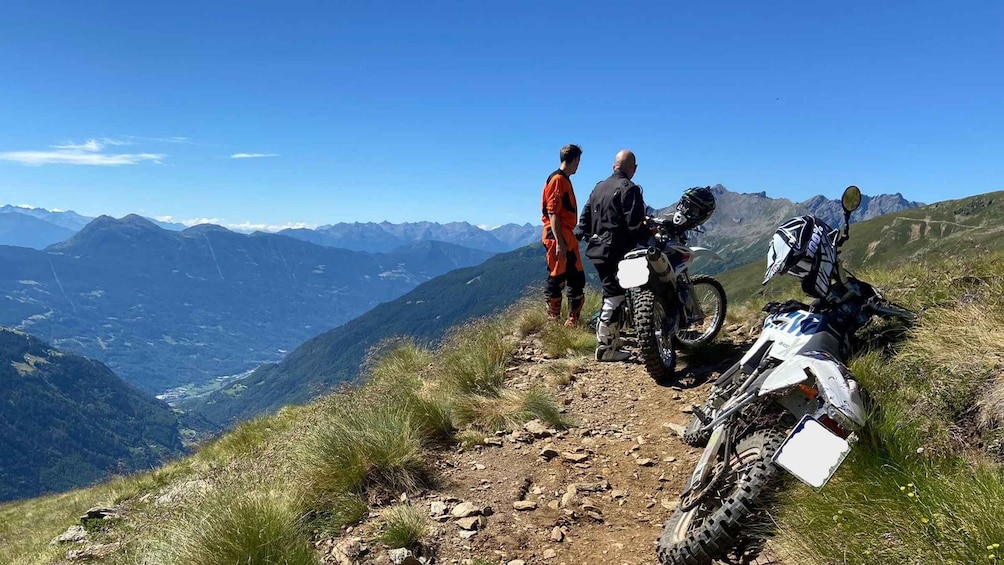 A mountain biker on a trail with a scenic view of mountains and a valley. 3
