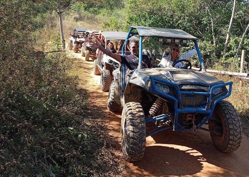 A group of off-road vehicles on a dirt path surrounded by greenery. 1