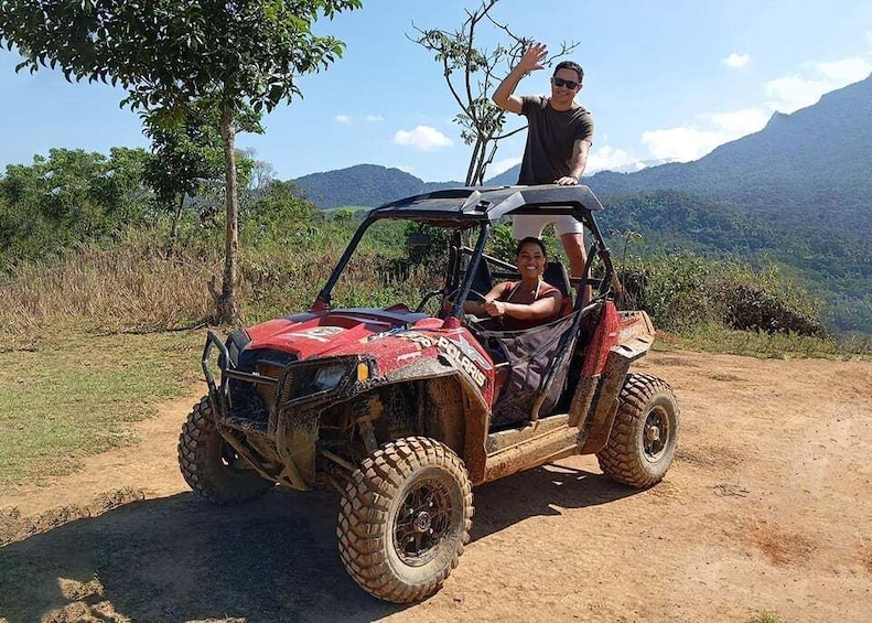 A red Polaris ATV on a dirt path with mountains in the background. 3