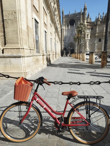 A red bicycle parked on a cobblestone street with a historic building in the background. 5