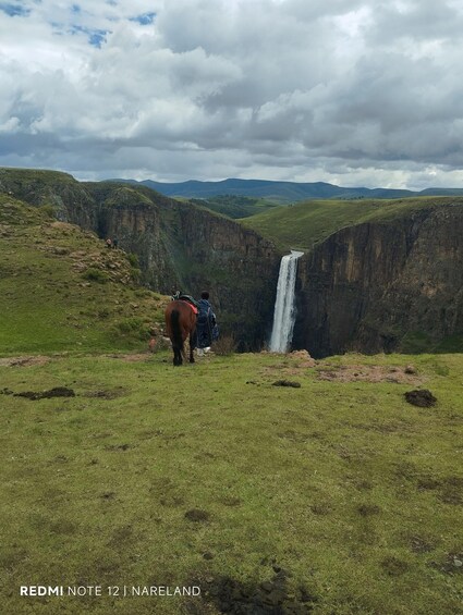 A waterfall in a valley with a horse and rider. 1