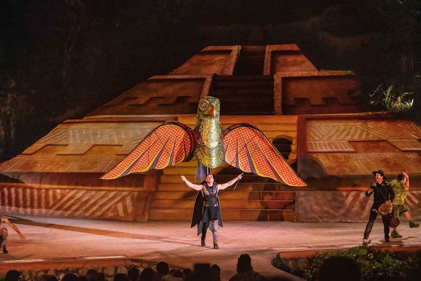 A performer with a large bird costume on stage. 5