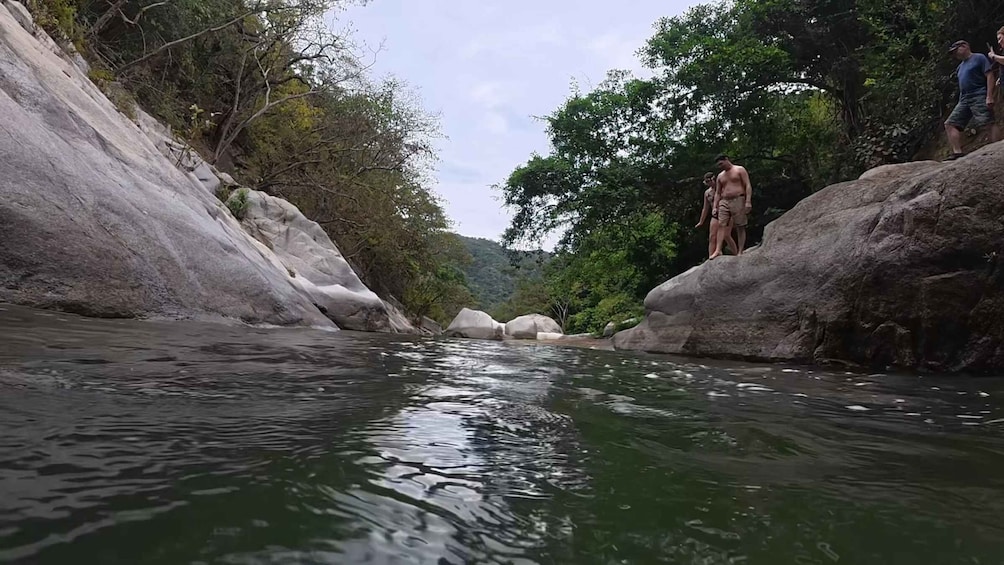 A river with large rocks and trees. 5