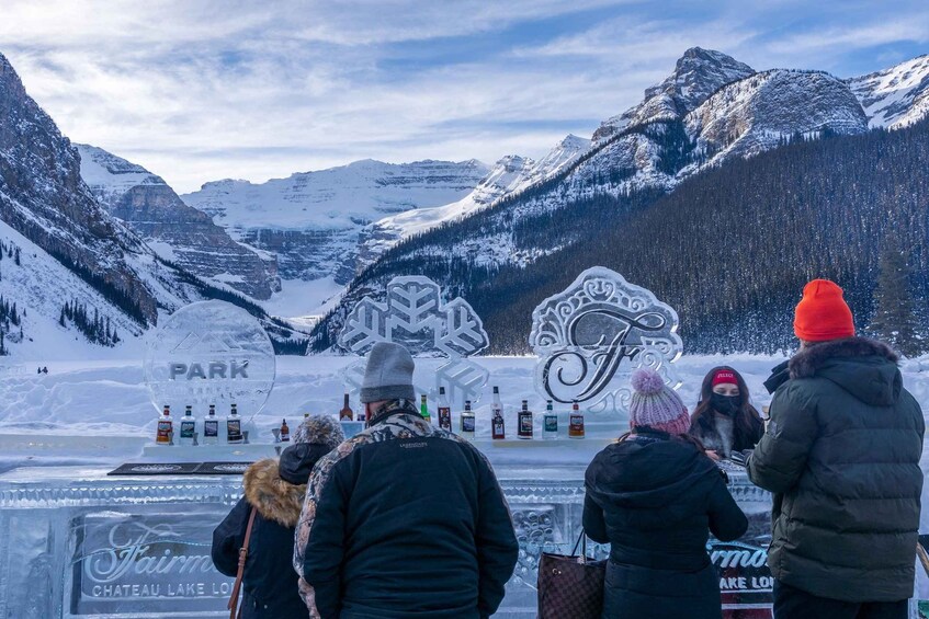 A snow-covered mountain landscape with a bar setup featuring bottles and a sign that reads 'PARK'. 2