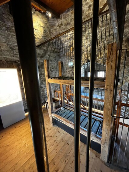 A rustic interior with stone walls, wooden beams, and a metal staircase. 5