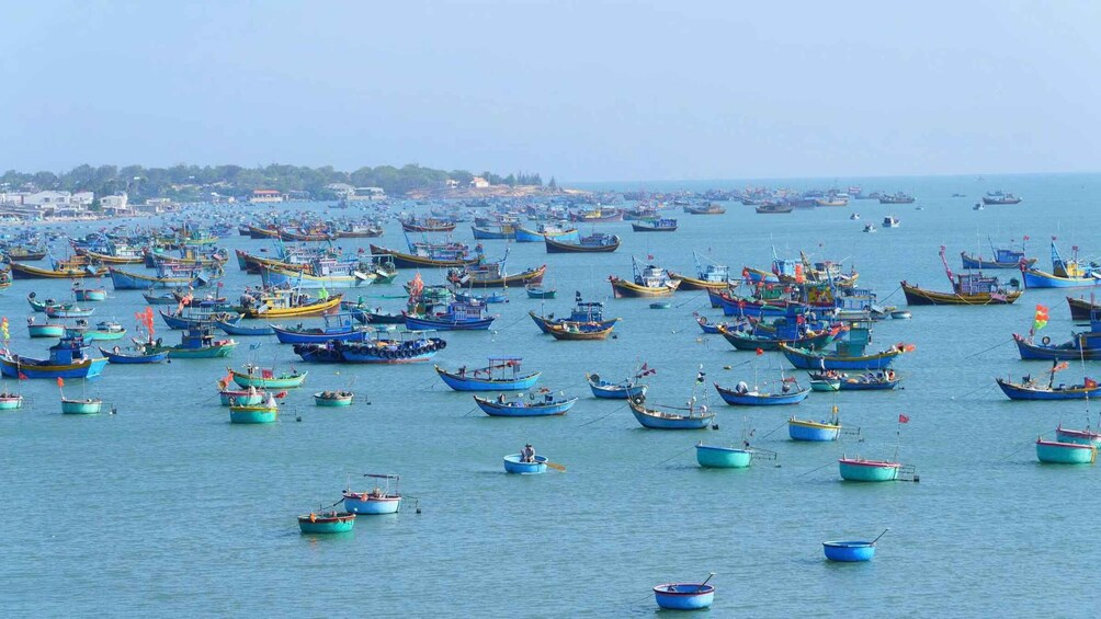A busy harbor with numerous fishing boats docked and anchored. 2