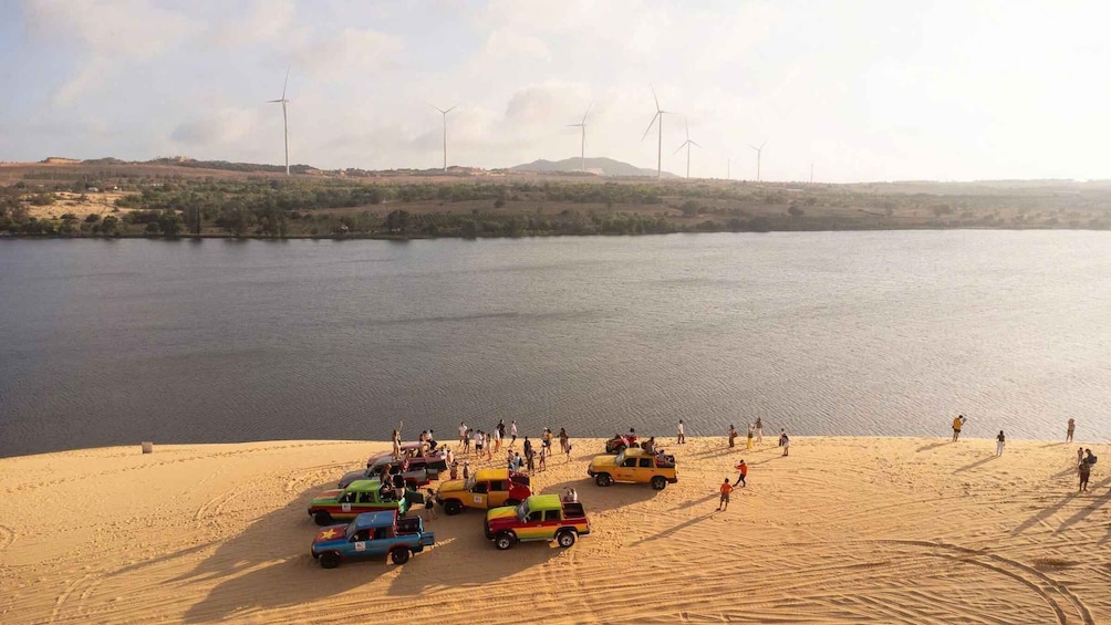 A desert landscape with a lake, people, and colorful toy cars. 3