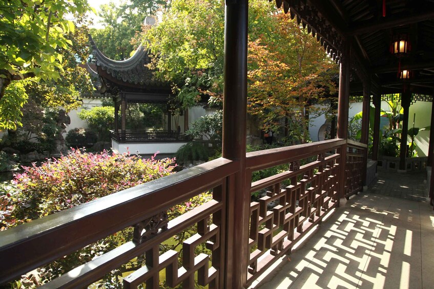 A traditional pavilion with intricate roof design, surrounded by lush greenery and flowering plants. 4