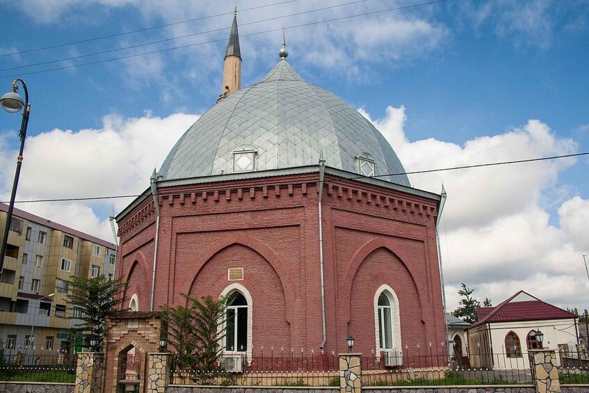 A red brick building with a large dome and a spire. 3