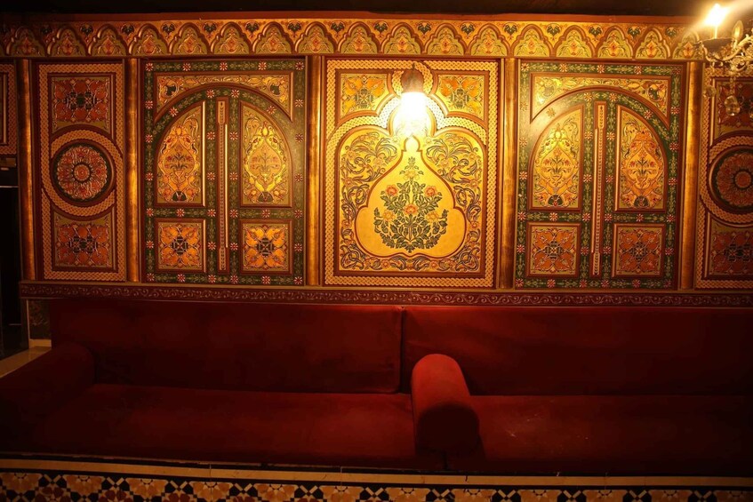 A richly decorated wall with intricate patterns and a central light fixture. 1